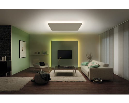 Wohnzimmer mit Deckenleuchte, Sofa, Sessel und Fernseher für eine helle und gemütliche Atmosphäre