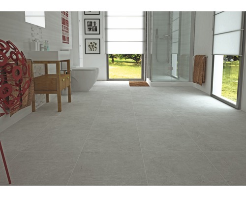 Helles Badezimmer mit grauen Fliesen, Toilette, Waschbecken und Dusche