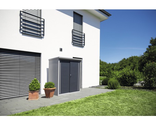 Metall Gerätehaus mit Schiebetür neben einem modernen Haus mit Jalousien