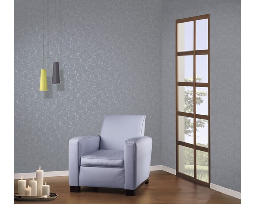 Wohnzimmer mit Sessel, Pendelleuchten, Kerzen und gemusterter Tapete