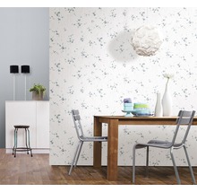 Helles Esszimmer mit Holztisch, Stühlen und floral gemusterter Tapete