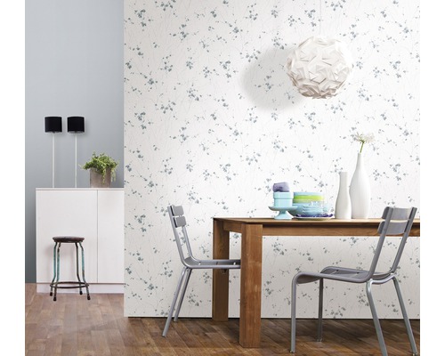 Helles Esszimmer mit Holztisch, Stühlen und floral gemusterter Tapete