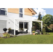 Überdachte Terrasse mit Gartenmöbeln und Grill vor einem Wohnhaus.