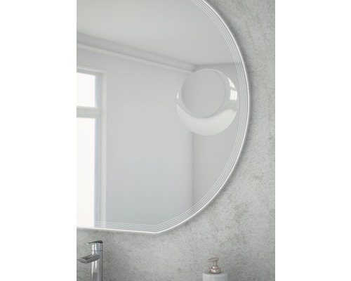 Detailansicht eines runden Spiegels im Badezimmer mit Armatur und Seifenspender