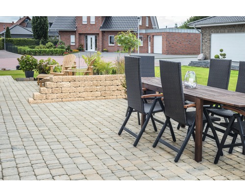 Außenbereich mit gepflasterter Terrasse, Gartenmauer und Sitzgruppe