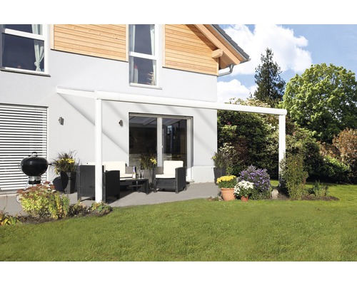 Überdachte Terrasse mit Gartenmöbeln und Grill neben dem Haus