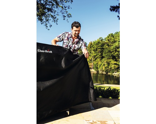 Mann legt Schutzhülle über Grill im Freien mit Char-Broil Logo