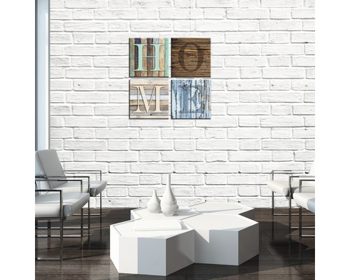 Dekorative Wandgestaltung mit vier Holzbildern, die das Wort HOME bilden, über einem Tisch und Stühlen in einem Wohnzimmer.