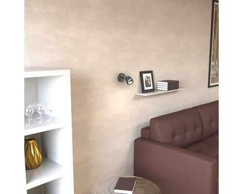 Wohnzimmer mit braunem Sofa, Regal, Dekoration und Wandleuchte