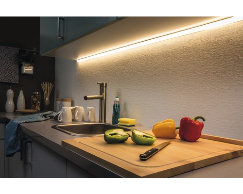 Küchenszene mit Schneidebrett, Paprika, Spüle, Wasserhahn und Küchenleuchte