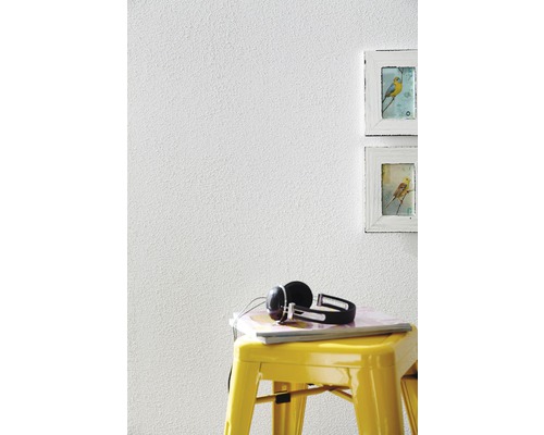 Raumansicht mit weißer Wandstruktur, gelbem Hocker, Kopfhörern und zwei Bilderrahmen