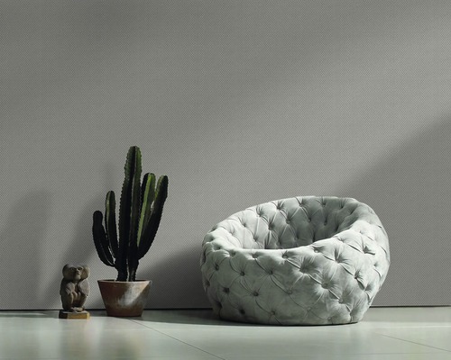 Wohnzimmer mit gemusterter Tapete, Sessel, Kaktus und Dekofigur
