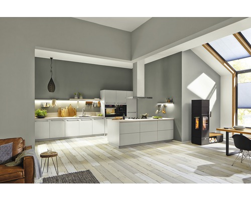 Heller Wohnraum mit offener Küche, Esstisch und Kaminofen