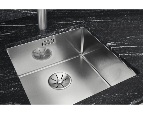 Spülbecken aus Edelstahl mit Ablaufsystem und schwarzer Arbeitsplatte