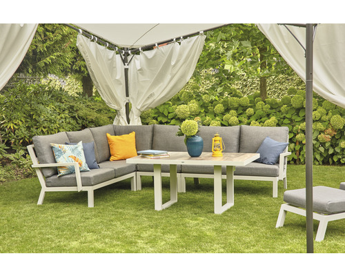 Gartenszene mit Ecksofa, Tisch und Pavillon auf Rasen