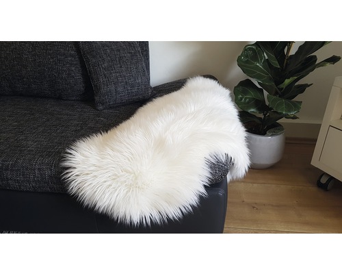 Weißes Schaffell auf einem grauen Sofa