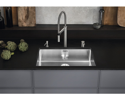 Spültisch aus Edelstahl mit Armatur und Seifenspender auf einer Küchentheke