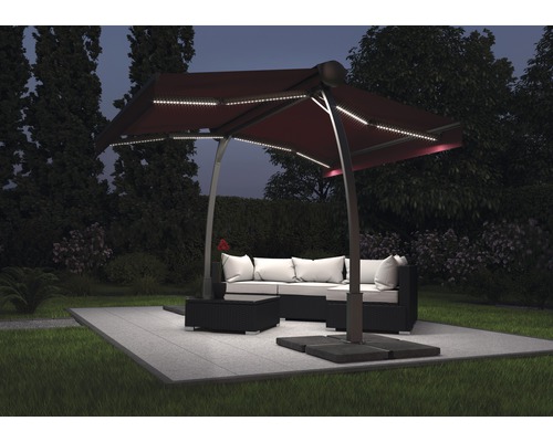 Szene im Garten mit einem Ampelschirm mit LED Beleuchtung über einer Loungegruppe