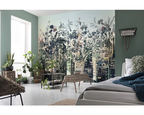 Helles Schlafzimmer mit Fototapete, die eine Stadtlandschaft mit floralen Elementen zeigt, ergänzt durch Pflanzen und helle Möbel.