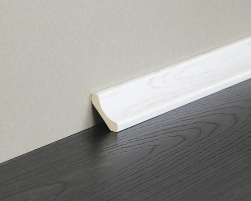 Weisse Sockelleiste aus Holz an dunklem Holzboden