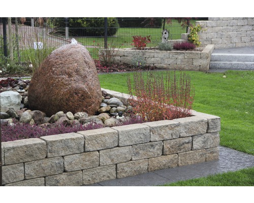Garten mit Natursteinmauer, Springbrunnen und Bepflanzung