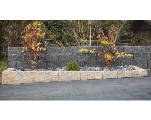 Gartenmauer mit Pflanzenbeet und Zierpflastersteinen