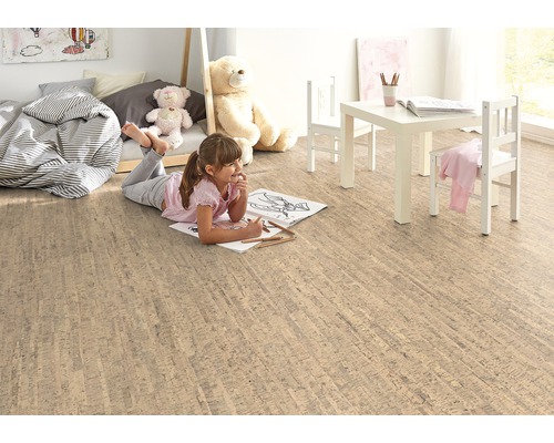 Helles Kinderzimmer mit Korkboden, Kindermöbeln und spielendem Mädchen