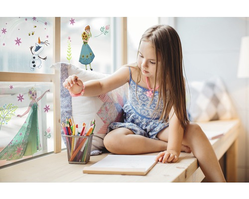 Mädchen sitzt am Fenster mit Frozen Wandtattoos, Stiften und Papier