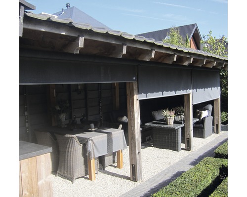 Überdachte Terrasse mit Rattanmöbeln und Rollo als Windschutz