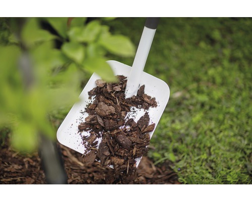Schaufel mit Rindenmulch im Garten