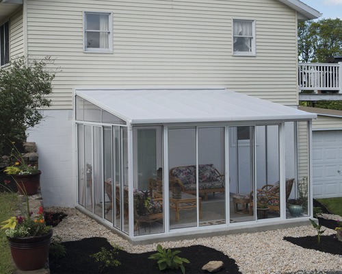 Wintergartenanbau mit Glaswänden und -dach an einem Wohnhaus.
