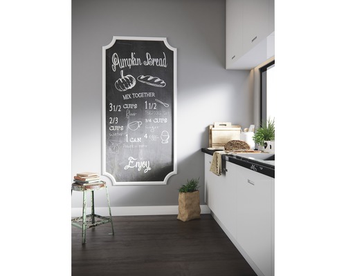 Küchenszene mit Kreidetafel mit Kürbisbrot-Rezept, Hocker und Küchendekoration