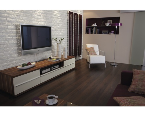 Wohnzimmer mit Fernseher, Kommode, Heizkörper und Sessel