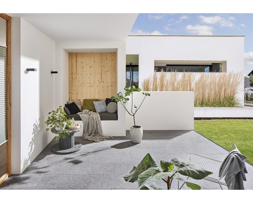 Modern gestaltete Terrasse mit Sitzbereich, Pflanzen und grauen Terrassenplatten.