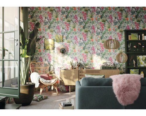 Wohnzimmer mit Dschungeltapete, Sofa, Sessel und Holzmöbeln für ein helles Ambiente.