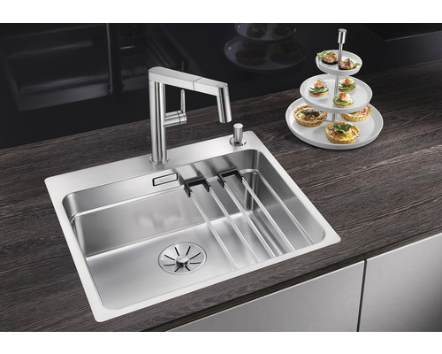 Edelstahlspüle mit Abtropfgestell und Armatur auf einer Küchentheke.