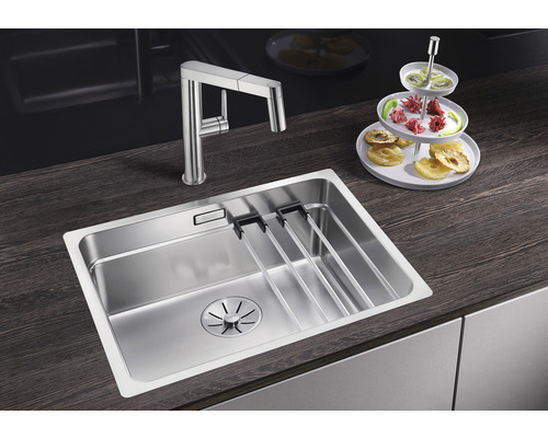 Edelstahlspüle mit Abtropfgestell und Küchenarmatur auf einer dunklen Arbeitsplatte