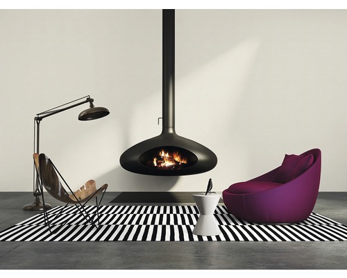 Wohnzimmer mit hängendem Kamin, Sessel und Stehlampe auf einem schwarz-weiß gestreiften Teppich