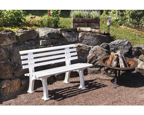 Weiße Gartenbank neben einer Feuerstelle im Freien