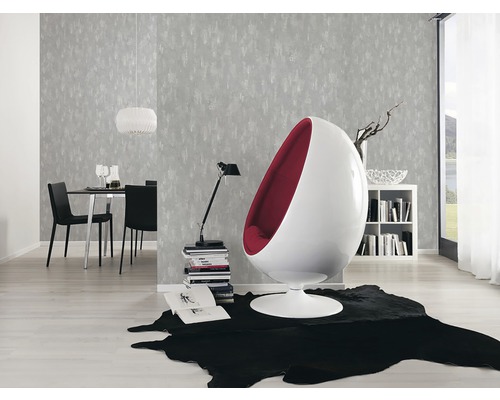 Heller Wohnraum mit grauer Muster-Tapete, schwarzem Teppich und modernem Sessel