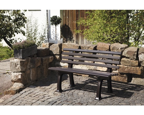 Gartenbank aus Metall vor Steinmauer