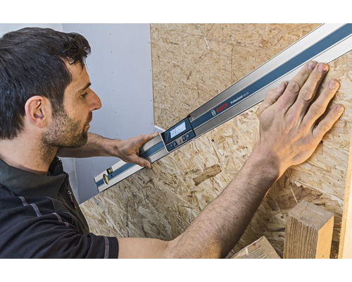 Handwerker misst Winkel mit digitalem Winkelmesser von Bosch an einer Holzplatte