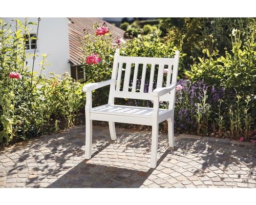 Gartenstuhl aus Holz vor blühendem Garten