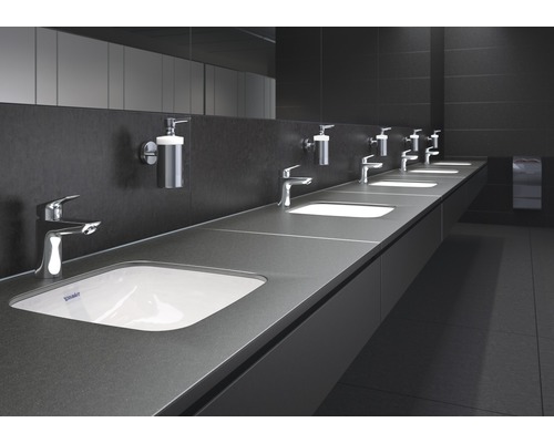 Reihe von Waschbecken mit Armaturen und Seifenspendern in einem öffentlichen Waschraum