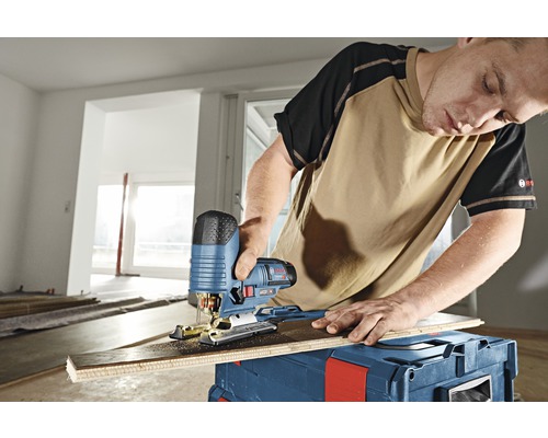 Mann schneidet Holzbrett mit Stichsäge von Bosch