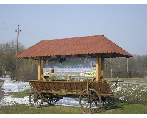 Informationsstand auf einem Holzfuhrwerk mit Dach und Hinweisschild für regionale Produkte.