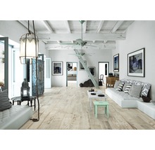 Heller, offener Wohnraum mit Holzboden, Sofa und dekorativer Beleuchtung