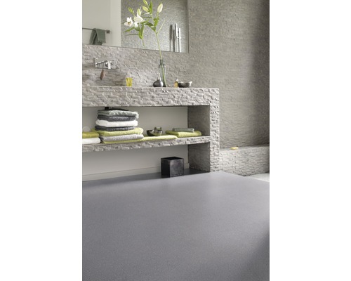 Badezimmer mit Waschbecken aus Stein, Handtüchern und grauem Boden