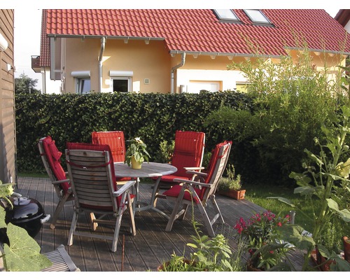 Gartenmöbel-Set auf Holzterrasse mit Haus im Hintergrund