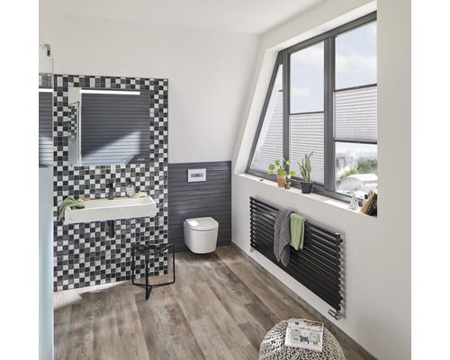 Helles Badezimmer mit Waschbecken, Toilette, Heizkörper und Fenster